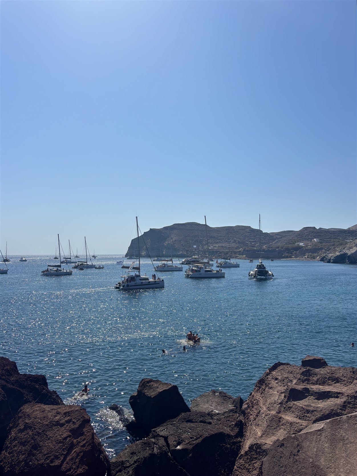 Zeilboten en catamarans in Amoudi Bay, Santorini