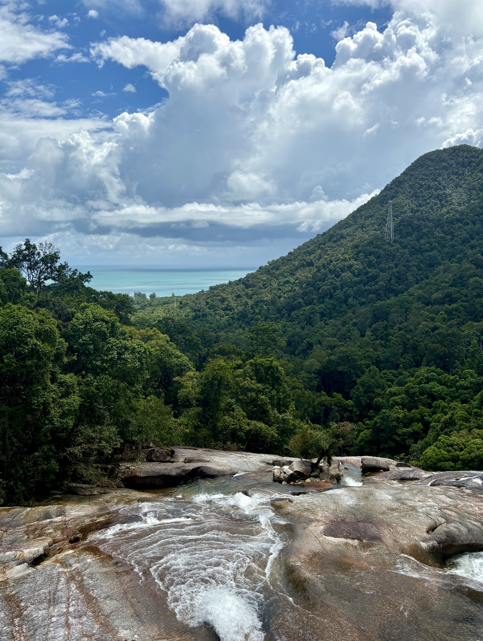 Uitzicht vanaf de top van de Seven Wells Waterfall, met de kabelbaanberg op de achtergrond